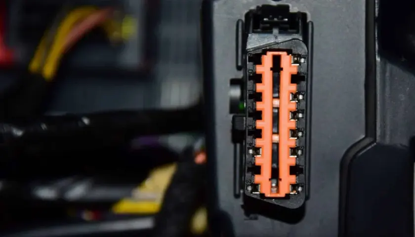 Nahaufnahme eines orangefarbenen Steckverbinders mit vielen Kontakten. Dies ist ein Teil der Elektronik, die für die Fahrdynamikregelung wichtig ist.