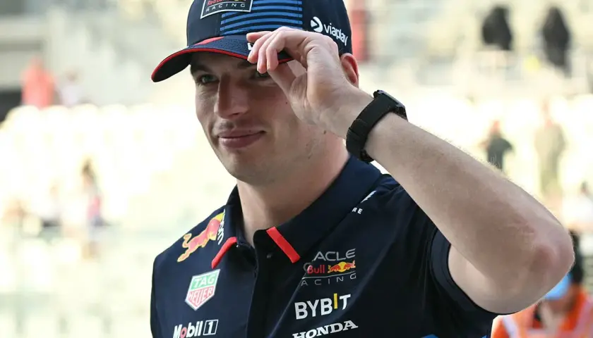 Max Verstappen in Red Bull Racing Kappe und Polo-Shirt, die Hand am Schirm.
