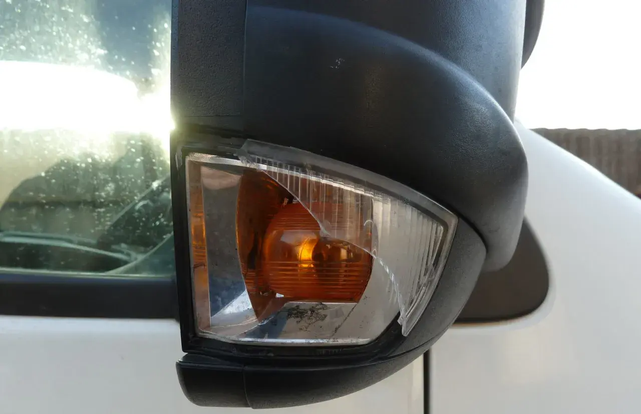 Nahaufnahme eines beschädigten Ford Transit Spiegelblinkers mit zerbrochenem Glas.