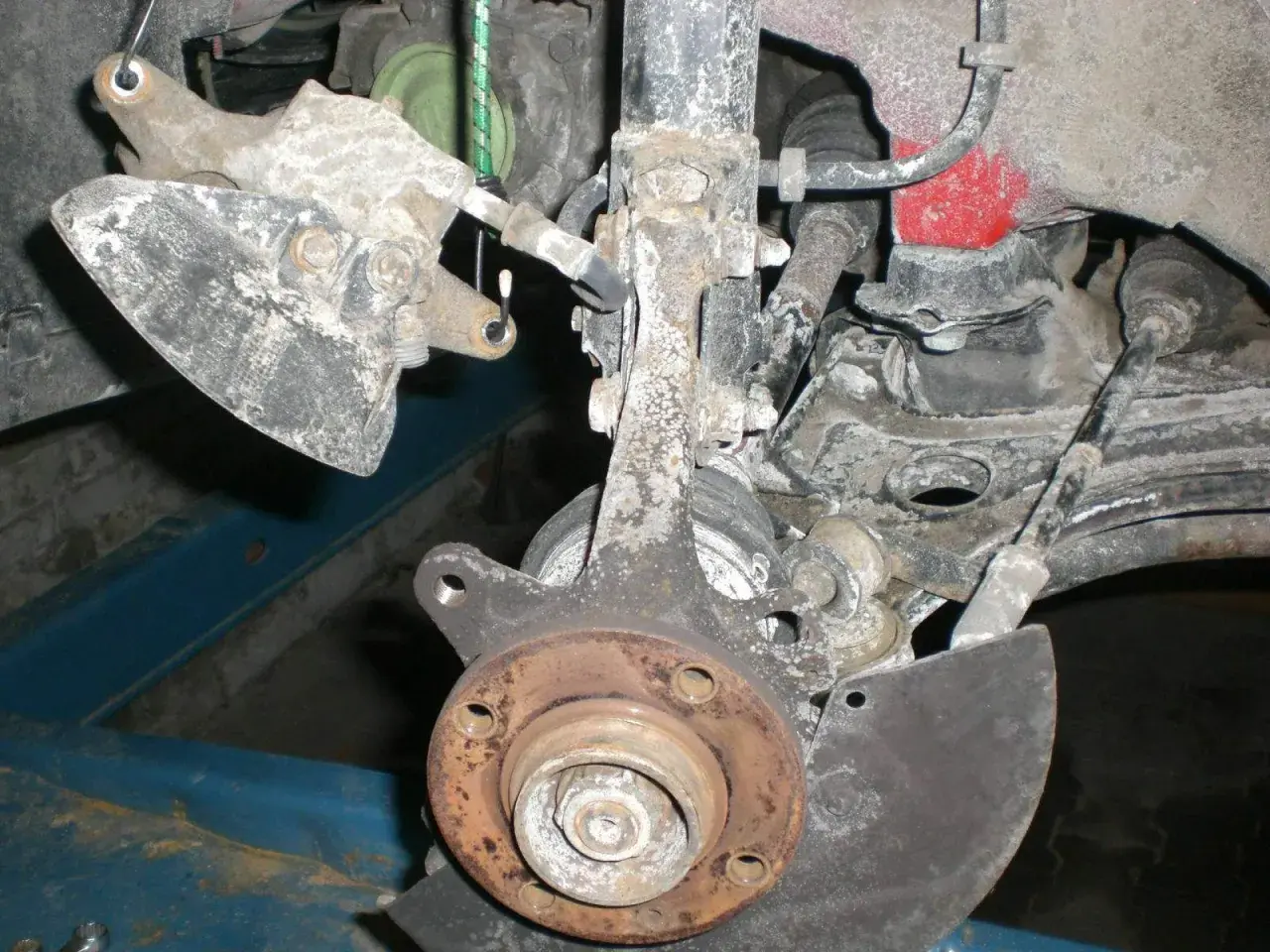 Vorderachse eines Golf 7, bereit für den Wechsel des Radlagers. Rostige Teile und Aufhängung sind sichtbar.