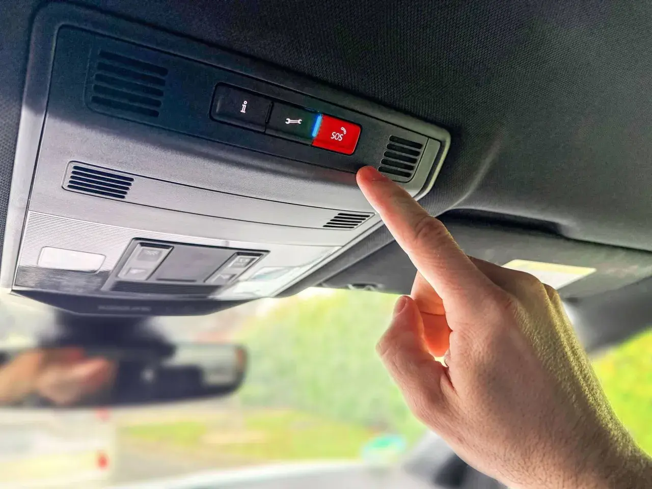 Finger drückt SOS-Knopf im Auto. In welcher Situation eCall auslöst, ist hier nicht ersichtlich, aber es ist ein Notruf.
