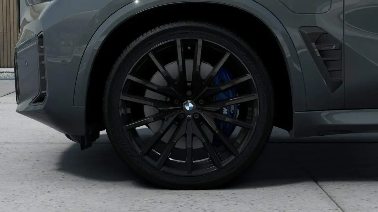 Nahaufnahme eines schwarzen BMW-Rads mit blauen Bremssätteln.