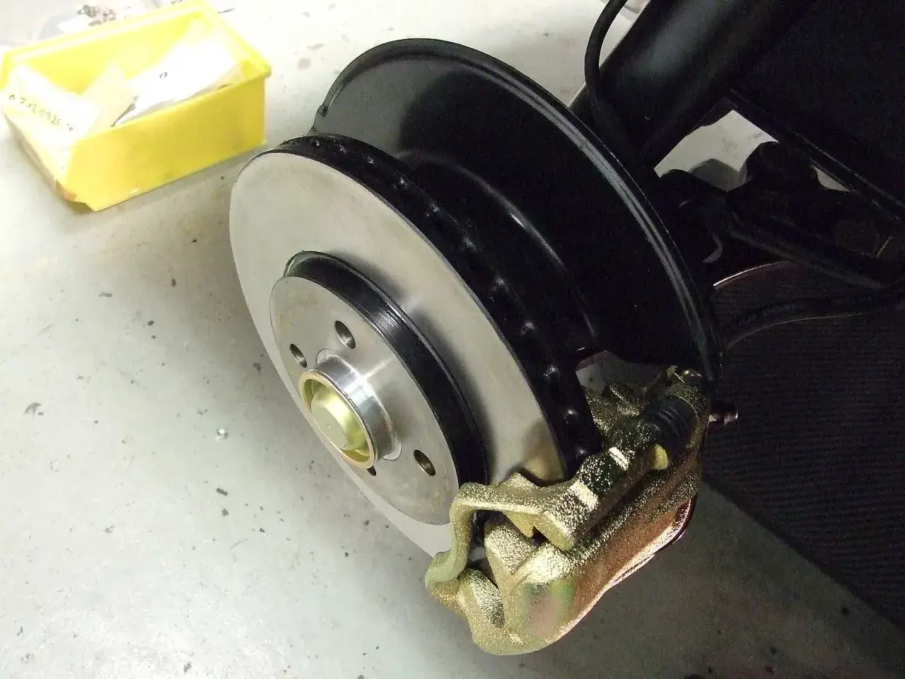 Frisch lackierte Bremsscheiben und ein goldener Bremssattel, bereit für den Einbau.