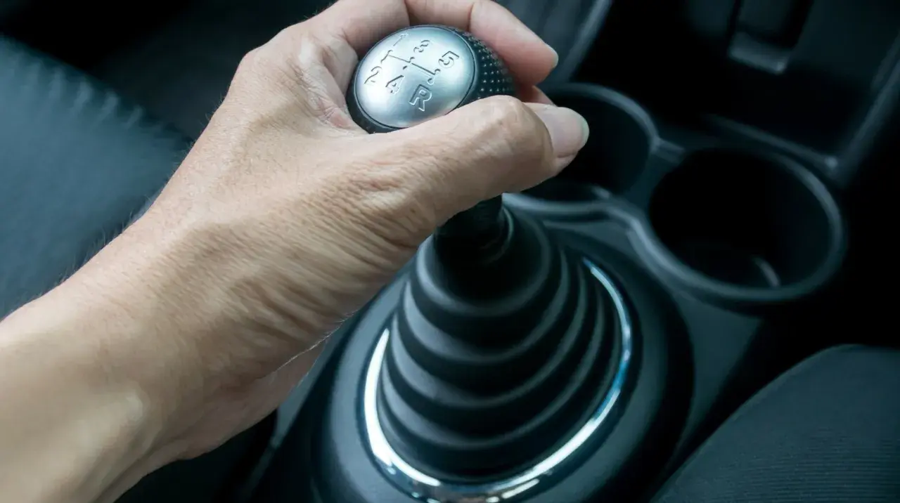 Hand schaltet mit der auto kupplung den Gang.