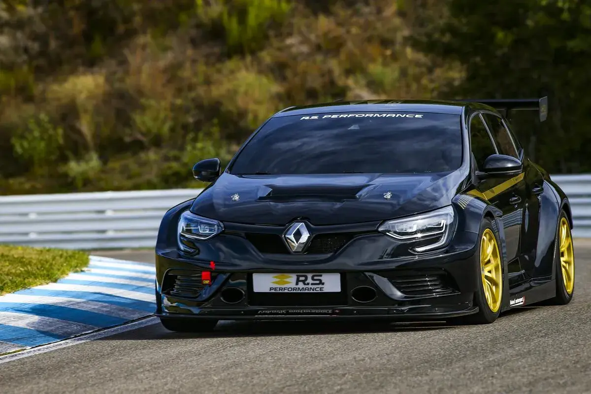 Schwarzer Megane 4 RS mit gelben Felgen auf Rennstrecke, bereit für Höchstleistung.