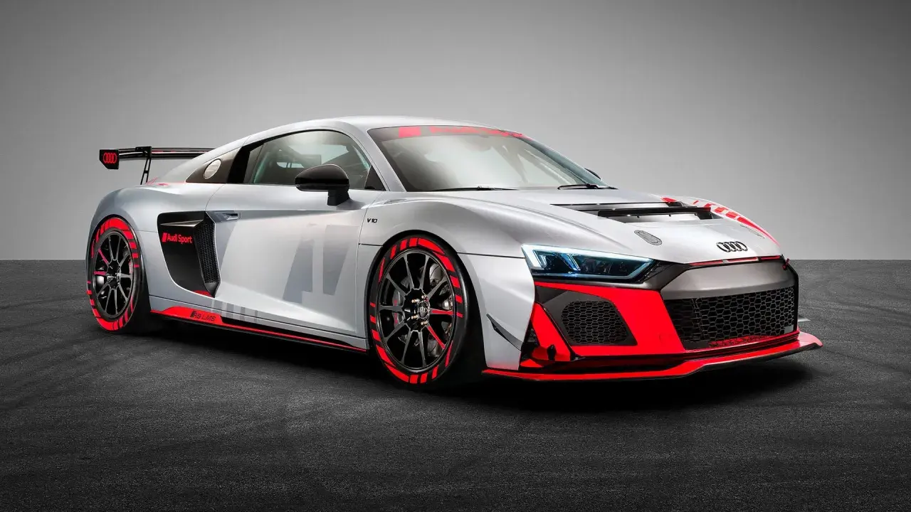 Silberner Audi R8 GT4 mit roten Akzenten, bereit für die Rennstrecke.