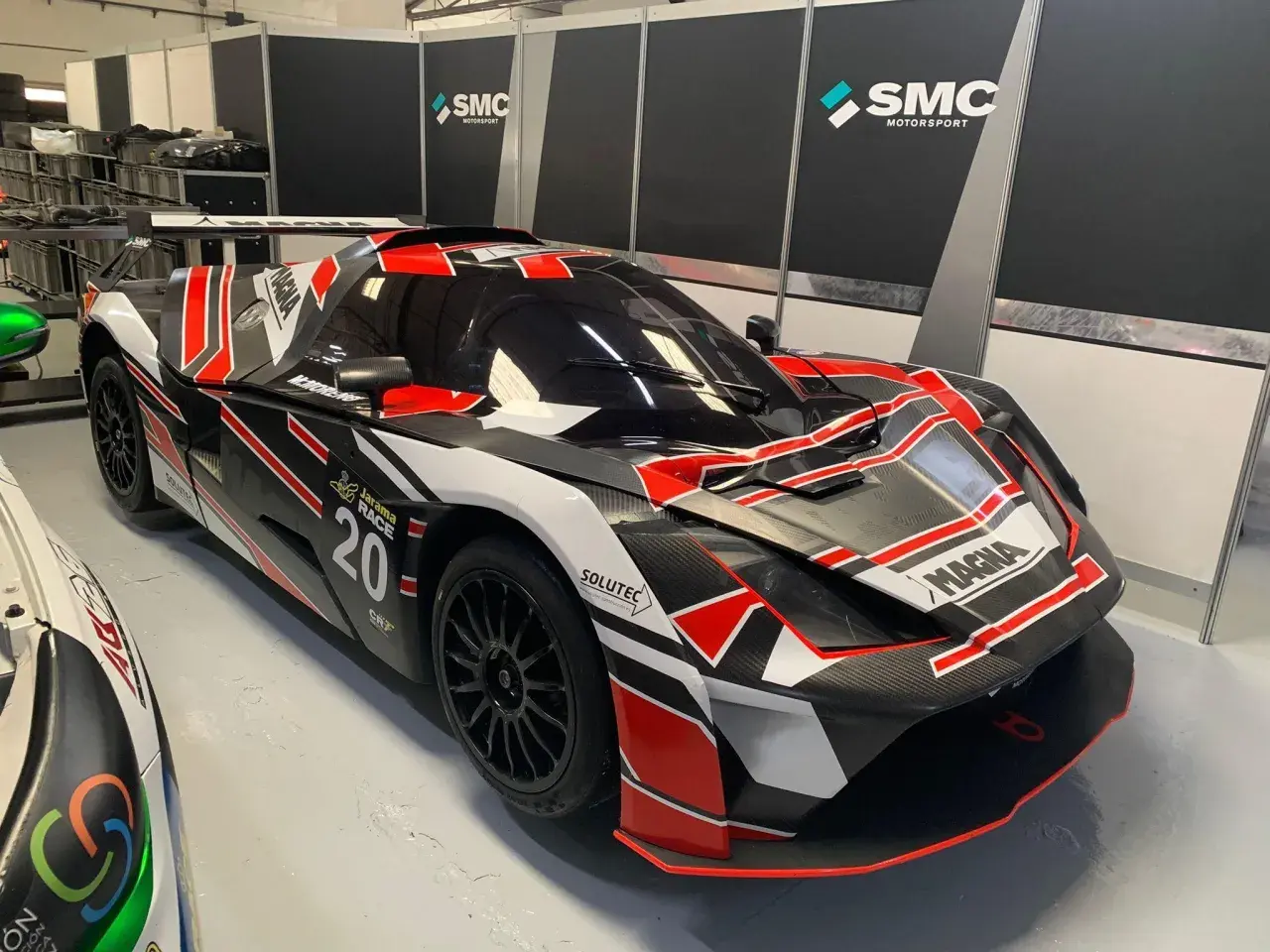 Ein rennfertiger KTM X-Bow GT4 in Schwarz mit roten und weißen Akzenten, bereit für die Jarama Race 20.