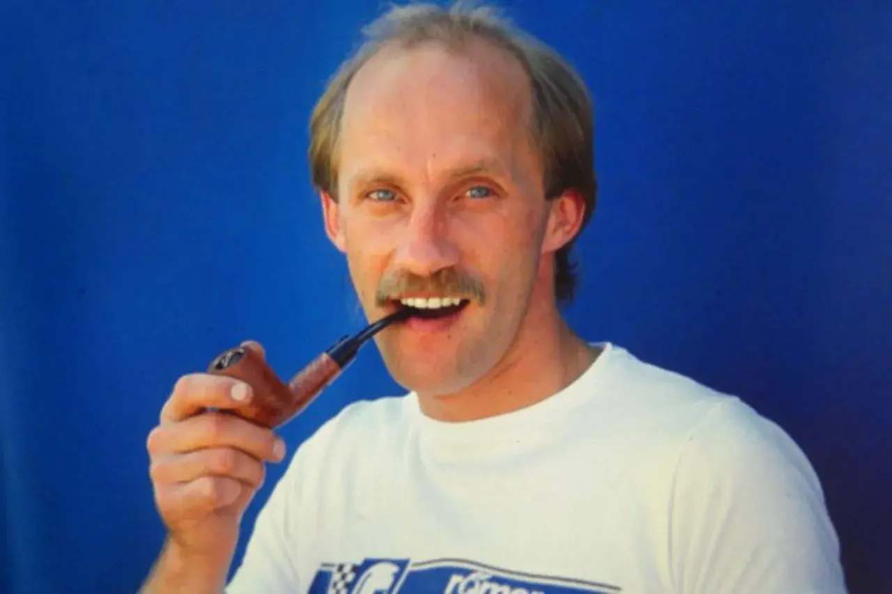 Ein Mann mit Schnurrbart, Reinhold Roth, hält eine Pfeife im Mund.
