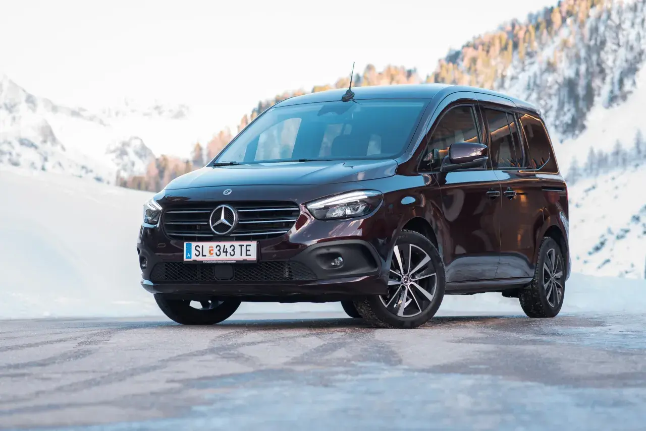 Dunkelroter Mercedes T 180 d im Schnee. Technische Daten sind hier nicht ersichtlich, aber das Fahrzeug wirkt robust für winterliche Straßen.