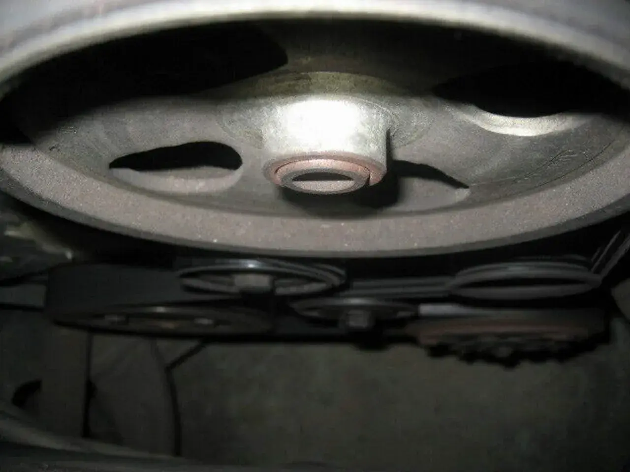 Detailaufnahme der Riemenscheiben und Keilriemen eines Peugeot 206, bereit für den Wechsel des Keilriemens.