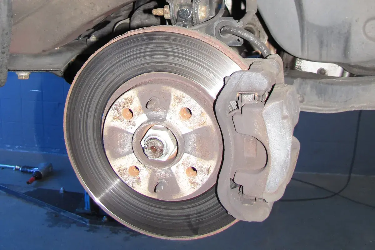 Nahaufnahme einer Bremsscheibe und eines Bremssattels. Ein Auto hat normalerweise vier Bremsscheiben.