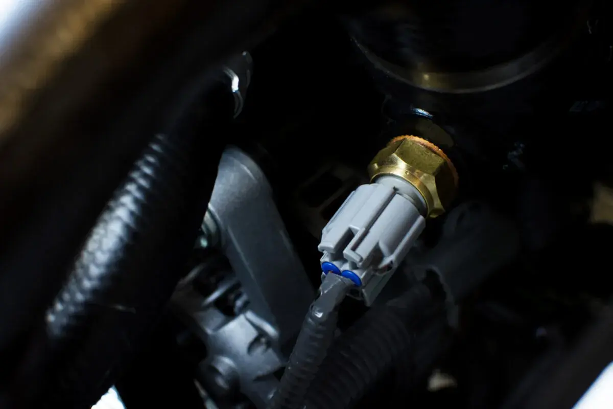 Detailaufnahme eines Temperatursensors, der für den **VW Touran 2.0 TDI Thermostat wechseln** benötigt wird.