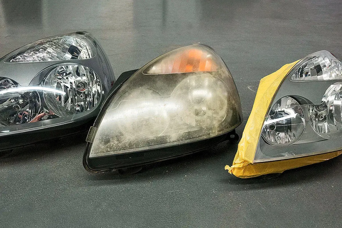 Scheinwerfer blind? Was tun? Drei Autoscheinwerfer nebeneinander: einer klar, einer trüb und einer abgeklebt.