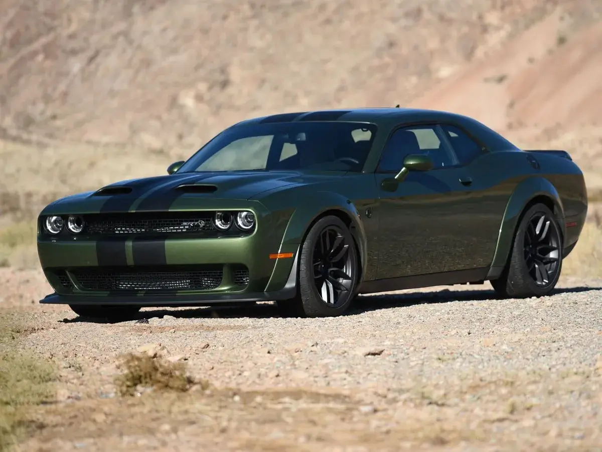 Grüner SRT Demon mit schwarzen Streifen parkt in der Wüste.