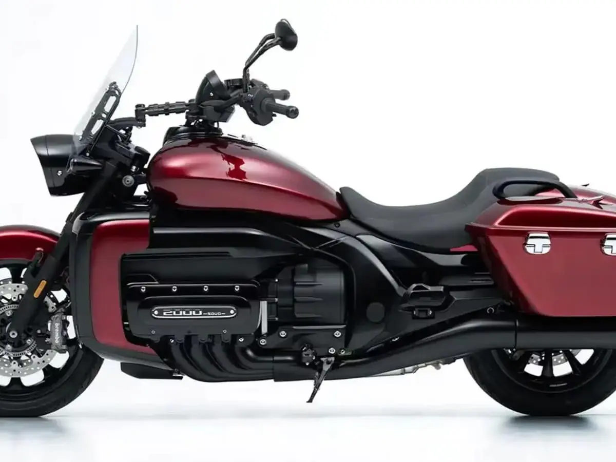 Rotes Motorrad mit großem Vierzylinder-Motor und Gepäcktaschen.