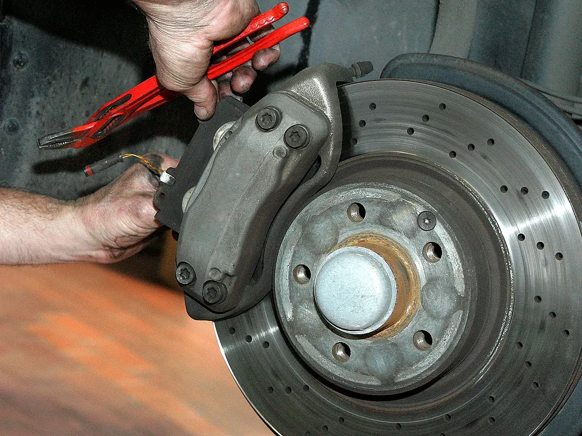 Mechaniker arbeitet an gelochter Bremsscheibe. Gute Quaro Bremsen Erfahrungen sind wichtig für die Sicherheit.