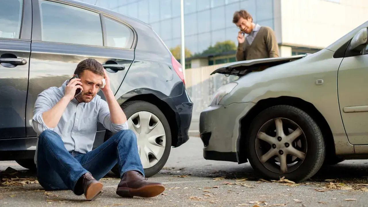 Mann sitzt nach Autounfall am Boden, ruft Hilfe. Der andere Fahrer spricht am Handy. Offenbar hat das **Auto bremst nicht mehr**.
