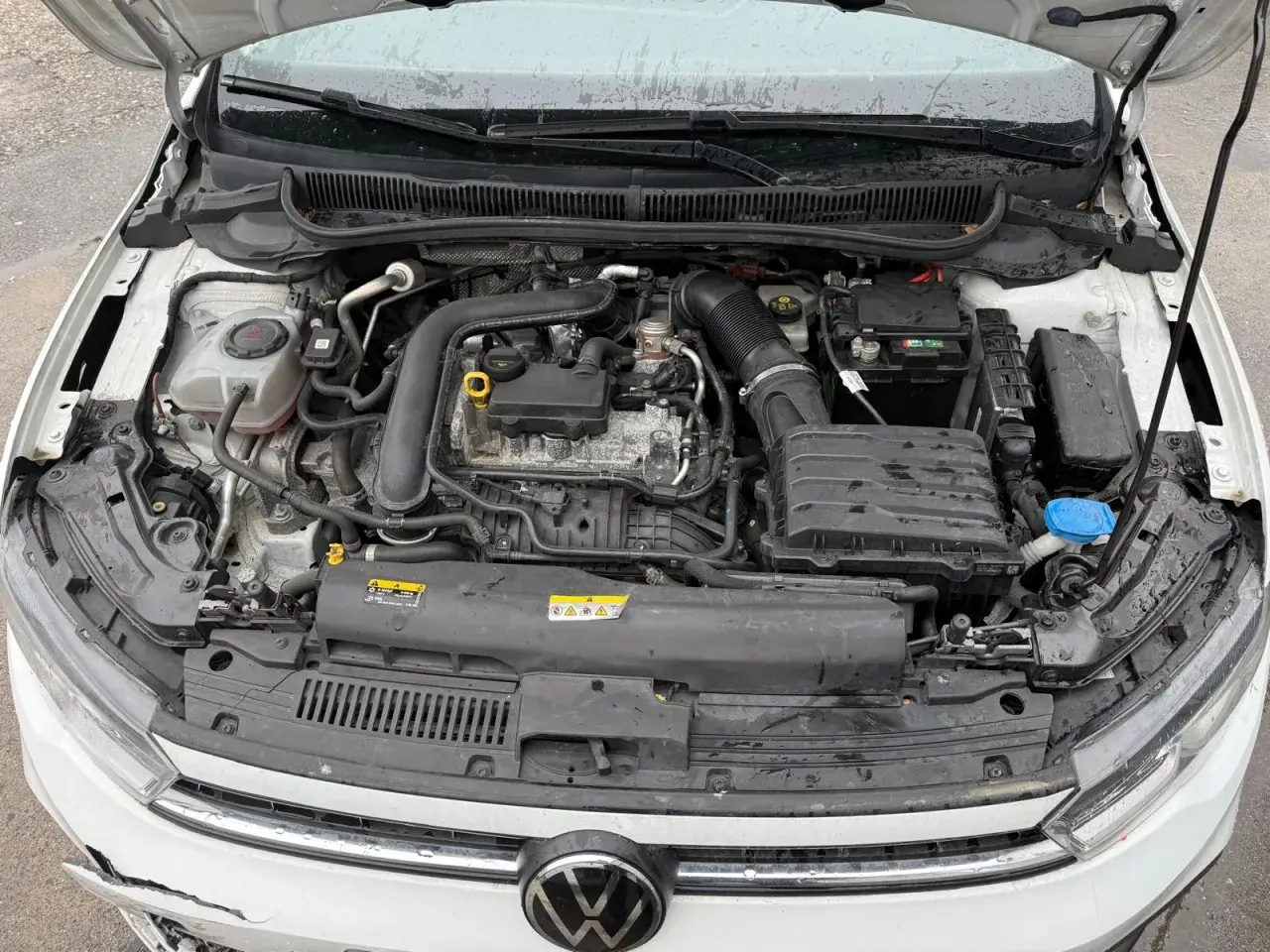 Motorraum eines weißen Volkswagen. Möglicherweise ein DTC P0301 (Zylinder 1 Fehlzündung) Hinweis auf ein Problem.