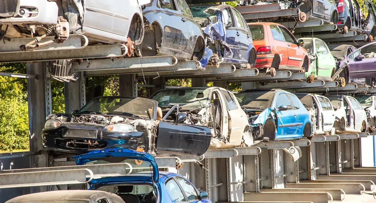Gestapelte Autos auf einem Schrottplatz. Hier werden alte Autoteile entsorgt und für das Recycling vorbereitet.