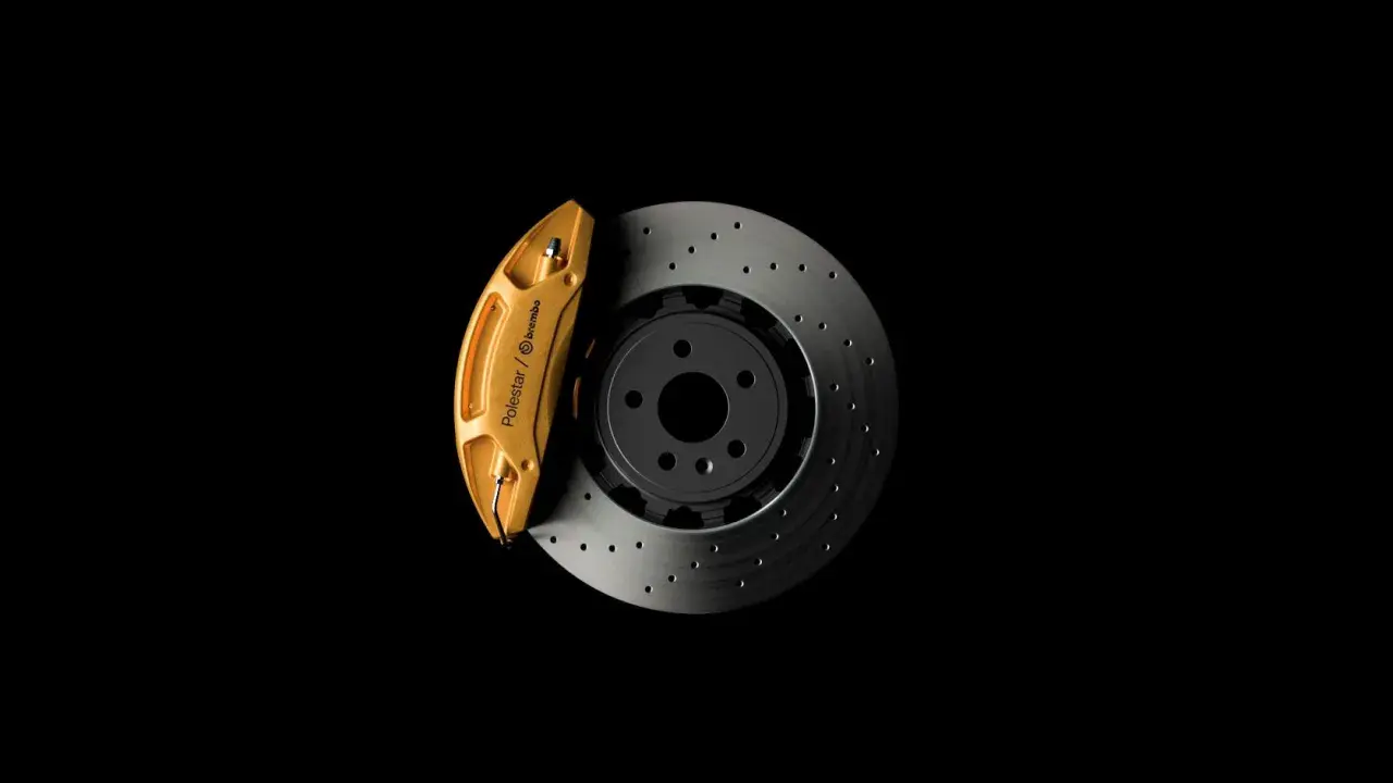 Goldener Bremssattel von Polestar/Brembo auf gelochter Bremsscheibe. So funktioniert eine Bremse: Reibung stoppt das Fahrzeug.