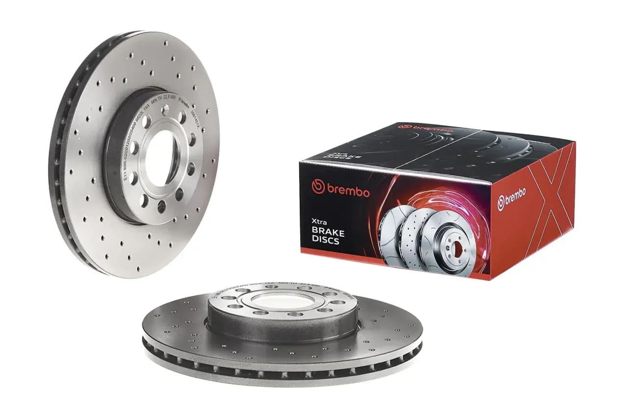 Zwei Brembo Bremsscheiben, eine im Vordergrund, eine daneben, und eine Verpackung mit dem Schriftzug "brembo Xtra BRAKE DISCS". Qualität, die man spürt, ob Brembo oder ATE.