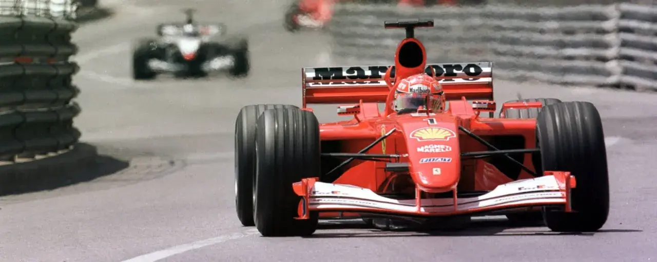 Ein roter Ferrari-Rennwagen rast auf der Strecke. Man fragt sich, was kostet ein Formel 1 Auto, wenn es so schnell ist?