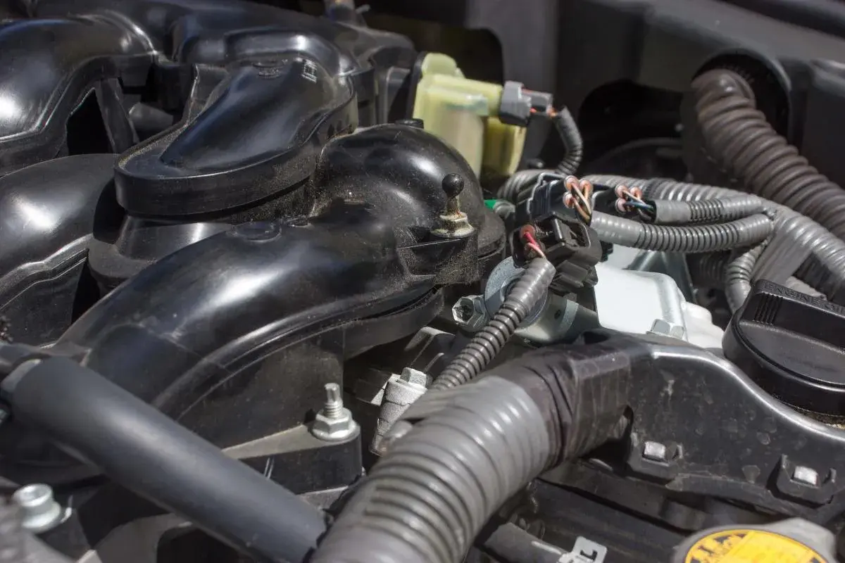 Detailaufnahme des Motors eines VW p0172. Schwarze Kunststoffteile und Kabelstränge sind sichtbar.