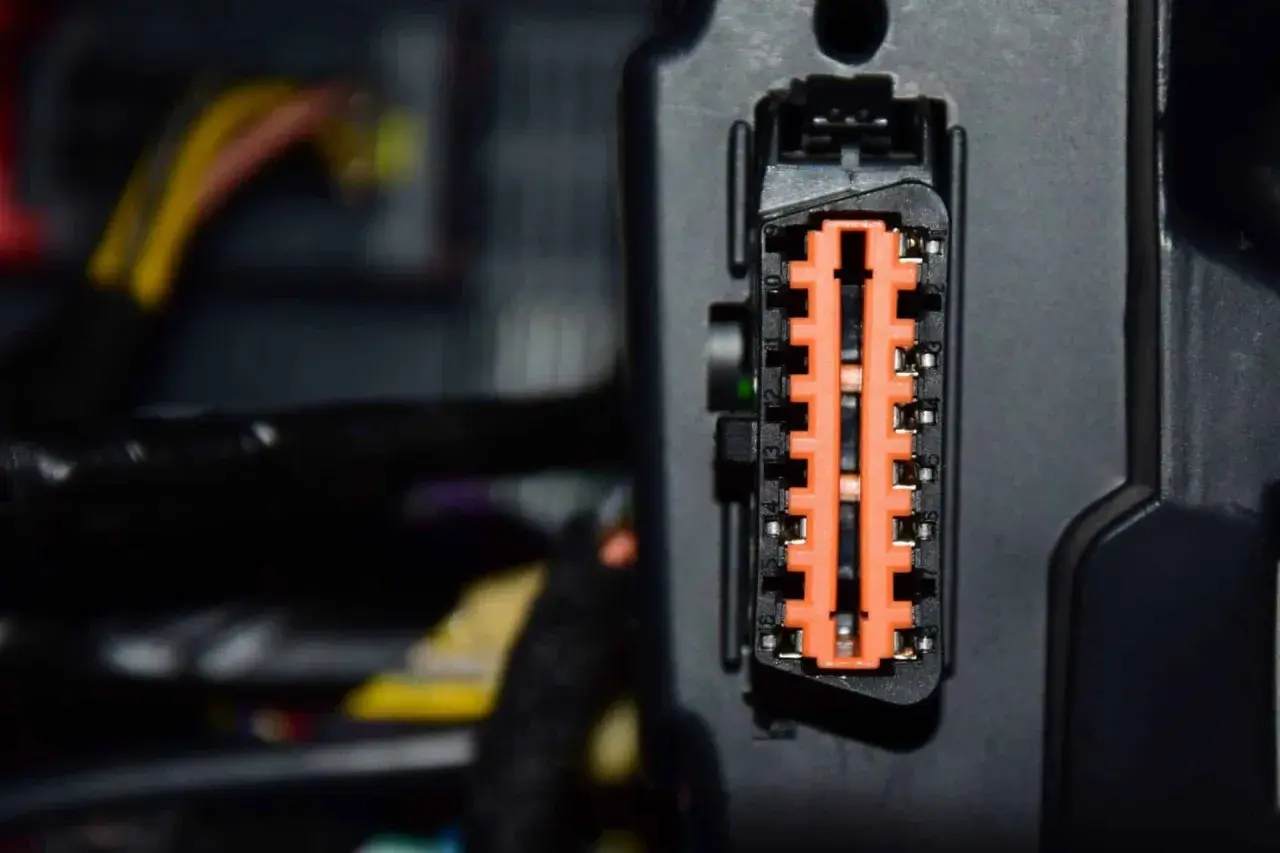 Nahaufnahme eines orangefarbenen Steckverbinders mit vielen Kontakten. Dies ist ein Teil der Elektronik, die für die Fahrdynamikregelung wichtig ist.