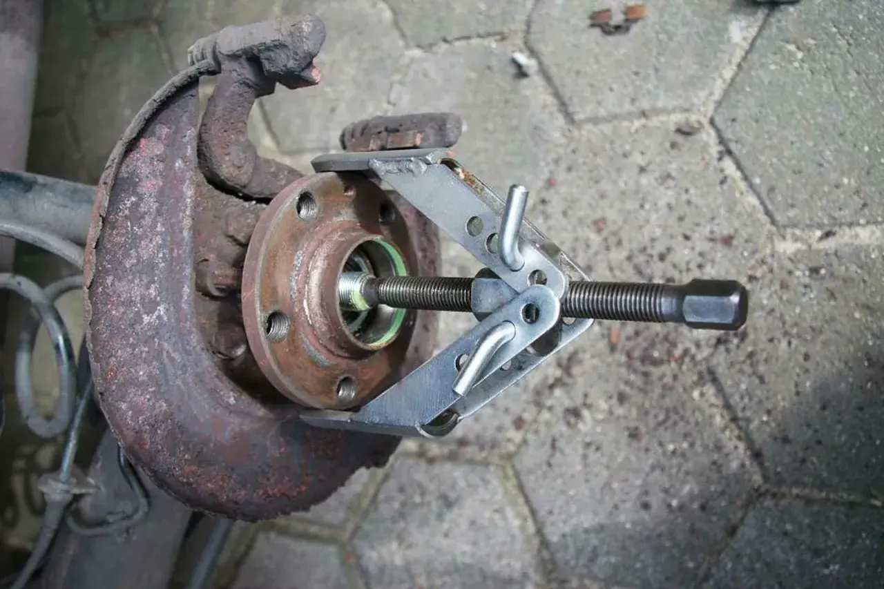 Werkzeug zum Wechseln des Ankerblechs vorne an einem Golf 7. Rostiges Bauteil wird mit Spezialwerkzeug gelöst.