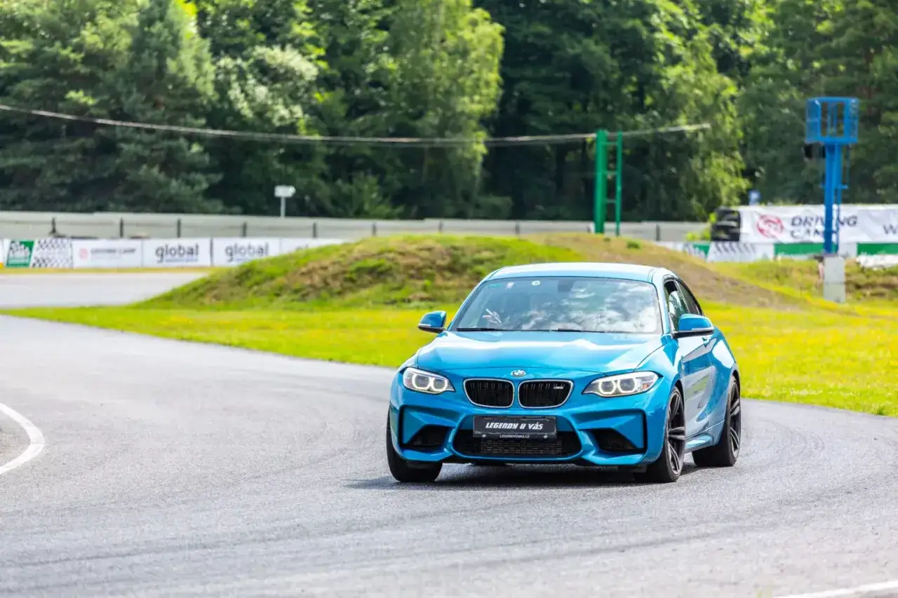 Ein blauer BMW F87 M2 fährt auf einer Rennstrecke.
