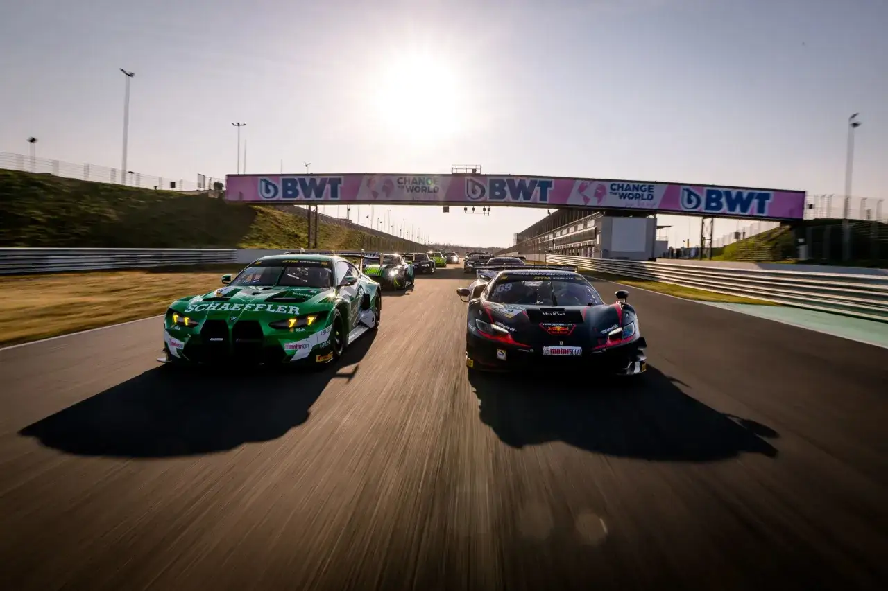 Rennwagen rasen auf der Strecke, ein grüner BMW und ein schwarzer Ferrari im Vordergrund. Das Bild fängt die Spannung von Motorsport im TV ein.