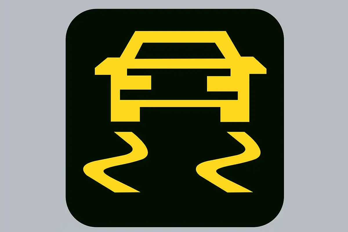Gelbes ESP-Symbol auf schwarzem Grund. Das Auto rutscht auf der Straße.