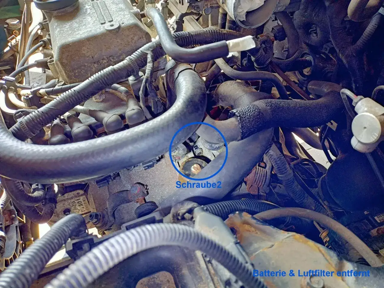 Motorraum eines Hyundai i30. Eine Schraube, die zum Wechseln des Anlassers benötigt wird, ist markiert. Batterie & Luftfilter sind entfernt.
