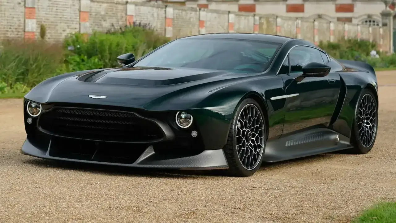Dunkelgrüner Aston Martin Victor mit markantem Kühlergrill und einzigartigen Felgen, bereit für eine Fahrt.