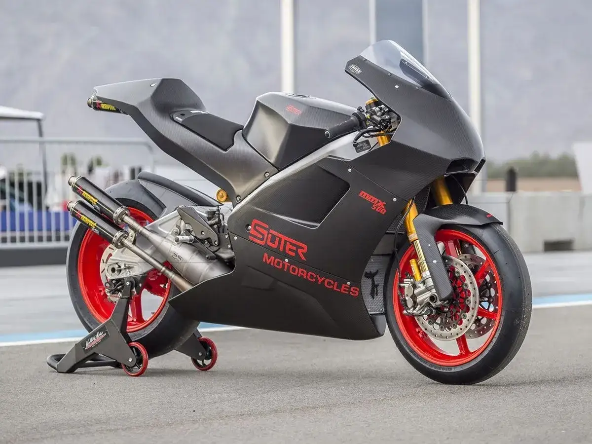Suter MMX 500 Rennmotorrad in voller Carbon-Verkleidung mit roten Felgen und Akrapovič-Auspuffanlage.