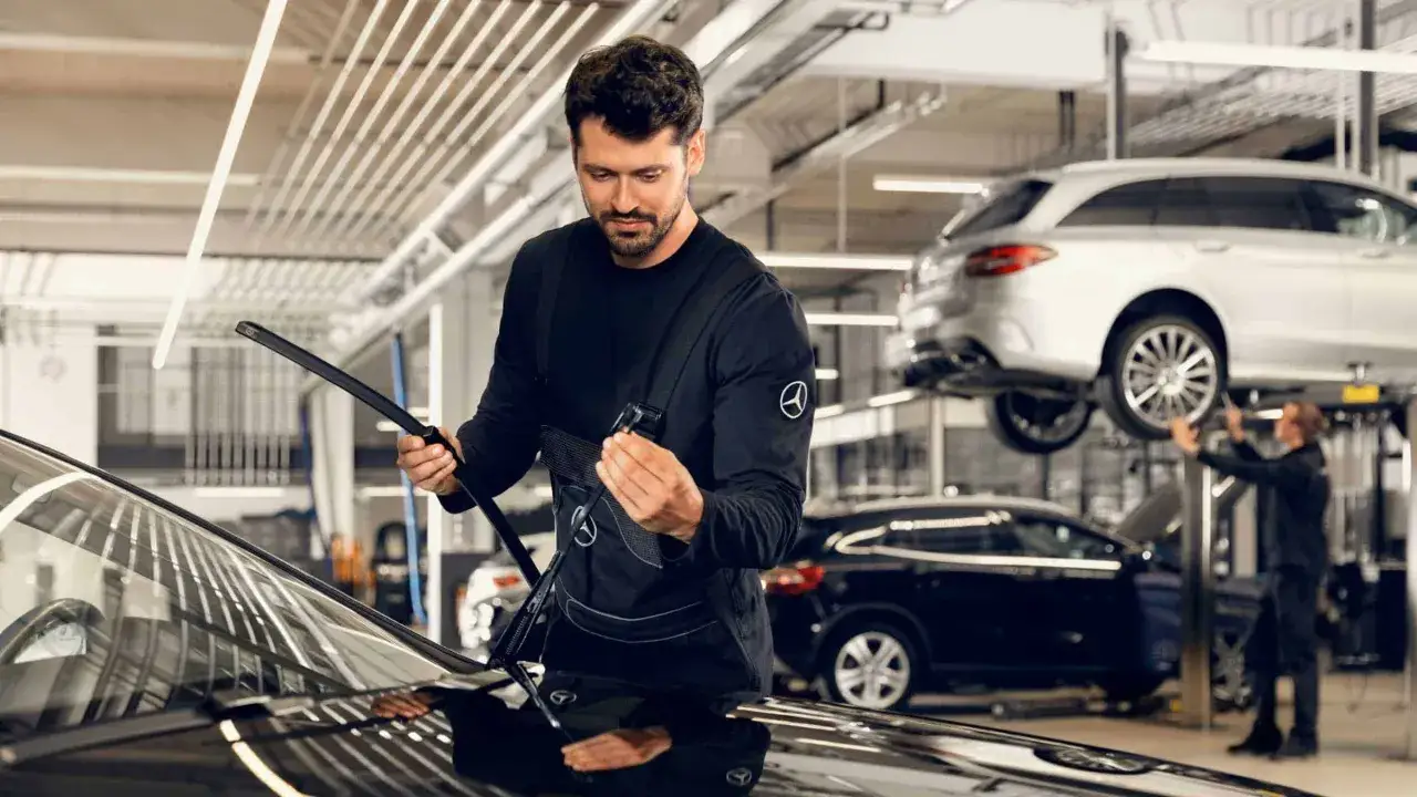 Mechaniker prüft Scheibenwischer. Informieren Sie sich über die Service B Mercedes Kosten und halten Sie Ihren Stern in Topform.