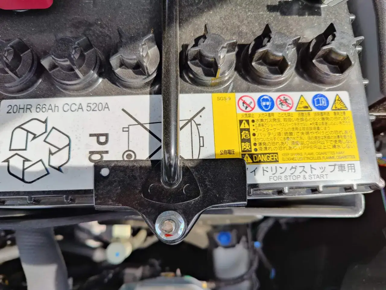 Mitsubishi Space Star: Batterie wechseln. Das Bild zeigt eine Autobatterie mit Warnhinweisen.