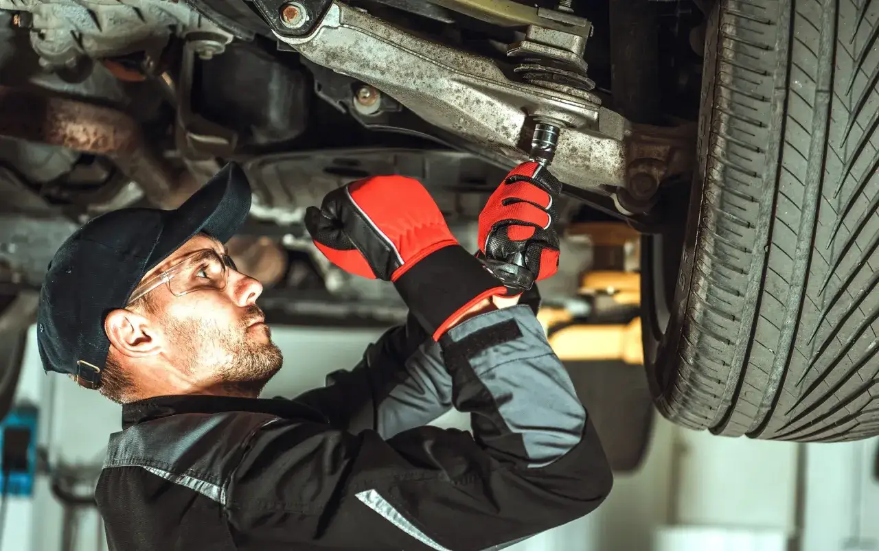 Mechaniker wechselt Querlenker. Informieren Sie sich über Querlenker wechseln Kosten bei der ATU.