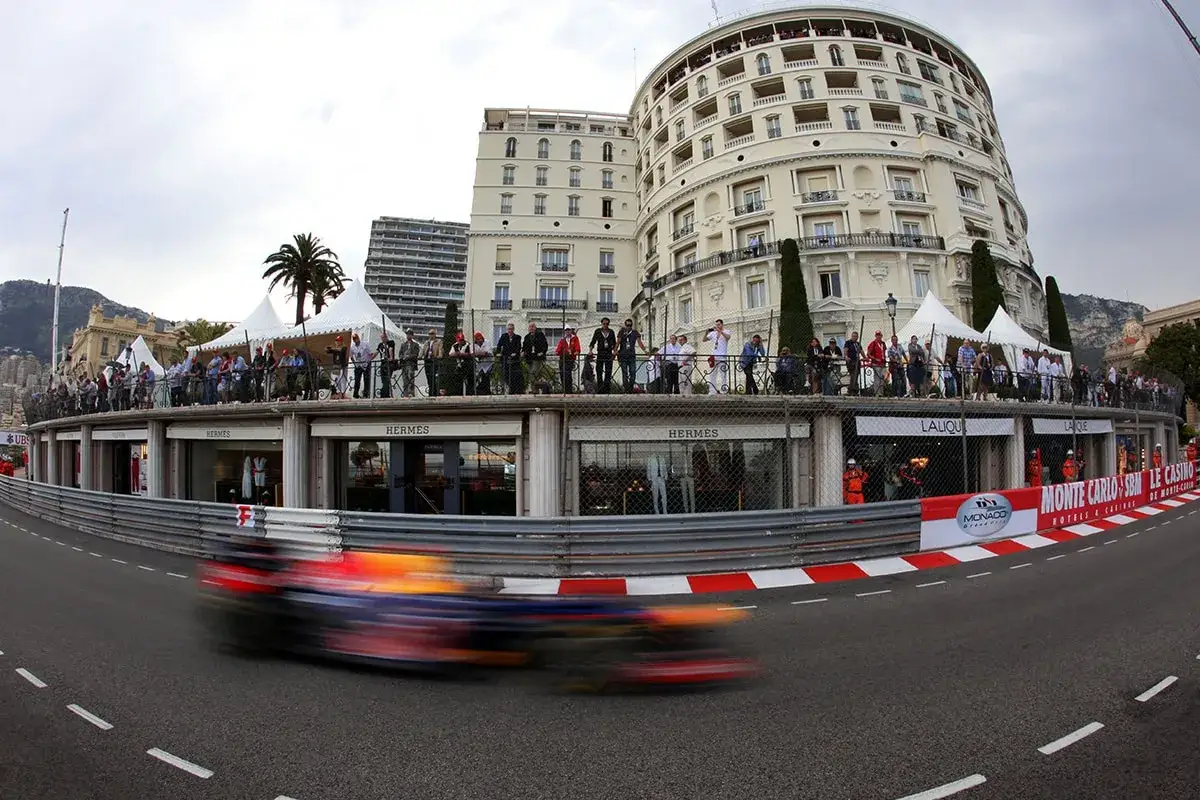 Formel-1-Bolide rast durch Monaco, Zuschauer auf Balkonen verfolgen das Qualifying.