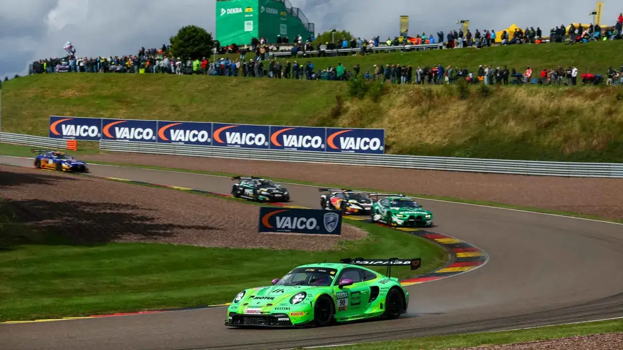 Grüne Rennwagen kämpfen beim DTM Sachsenring um die Führung. Zuschauer säumen die Strecke.