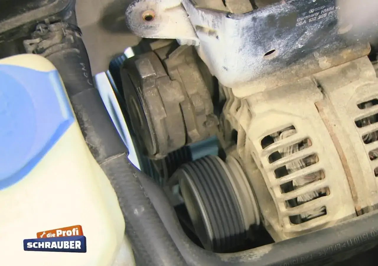 Detailaufnahme des Motors eines Opel Adam. Der Keilrippenriemen wird gewechselt. Man sieht den Generator und Spannrollen.