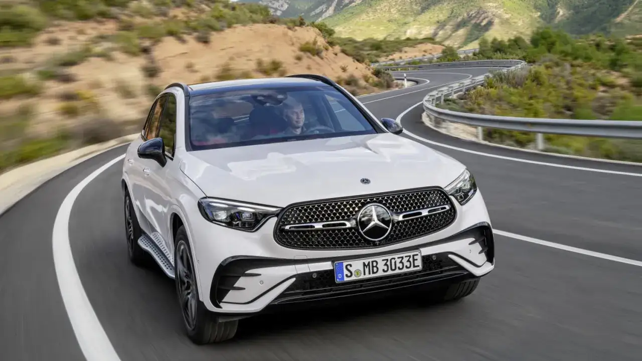 Weißer Mercedes GLC 300 de Hybrid auf kurviger Bergstraße. Technische Daten im Blick, bereit für die nächste Fahrt.