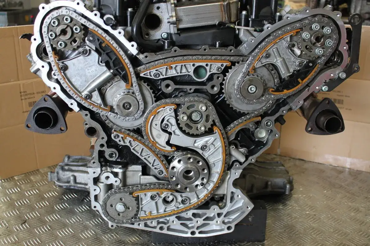 Detailansicht des Motors mit sichtbaren Steuerketten. Ein Audi 3.0 TDI Steuerkettenwechselintervall ist hier zu sehen.