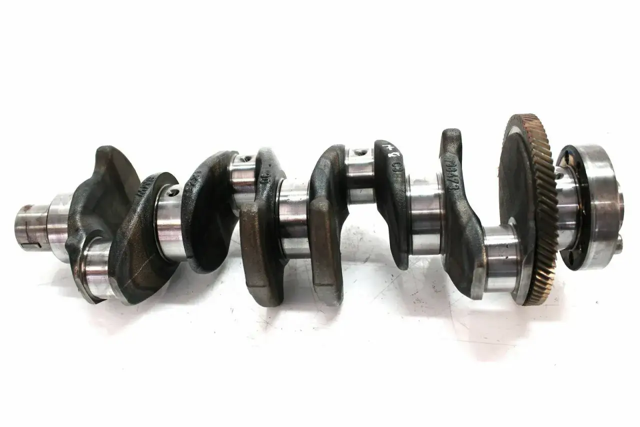 Metallische Kurbelwelle mit Zahnrad. Mögliche kurbelwelle defekt symptome sind ungewöhnliche Geräusche oder Vibrationen.
