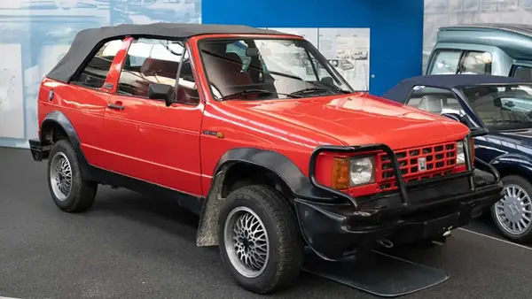 Roter Biagini Passo Cabriolet mit schwarzem Verdeck und auffälligem Kühlergrill-Schutz.