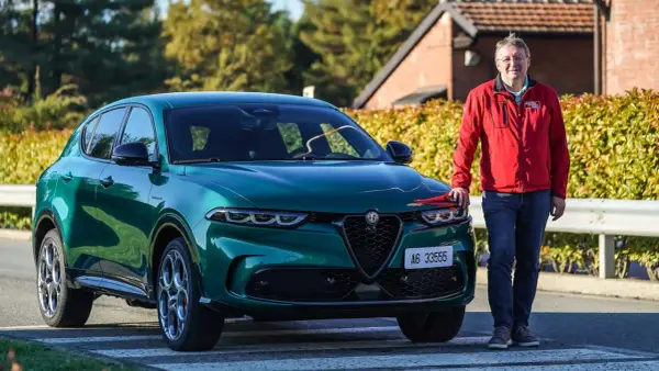Ein Mann steht neben einem grünen Alfa Romeo Tonale, einem Alfa Romeo Plug-in Hybrid.